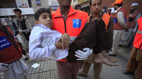 Rescue workers carry a boy, who was injured in a suicide bomb blast, to the Lady Reading Hospital for treatment in Peshawar